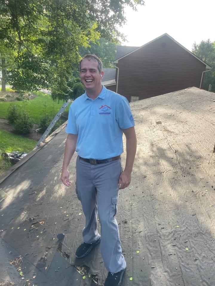 Aub Holley, founder of Helping Hands Roofing, on a roof during a project.