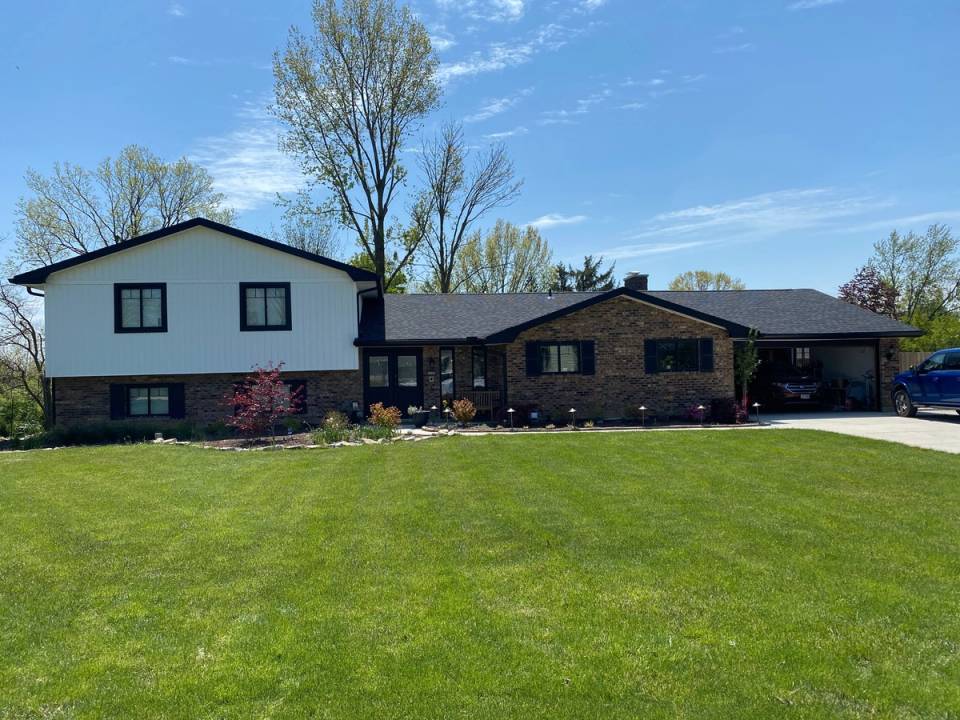 The finished house from the front lawn, the upper story in white board-and-batten siding above the brick, Beavercreek, Ohio.